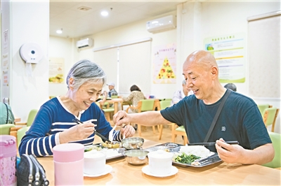 两位老人在天河区居家养老服务示范中心的长者饭堂用餐。