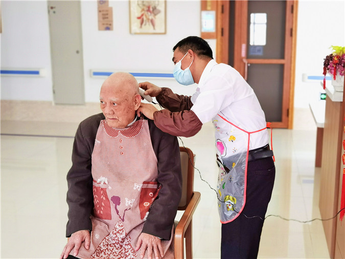 图1：养老护理员张其汪在下班时间志愿为老人理发.jpg