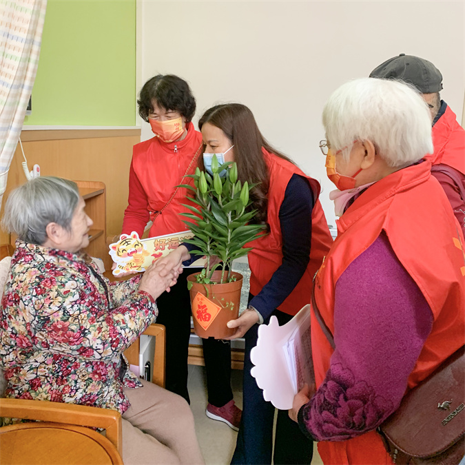图4：志愿者将鲜花和新春祝福送到老人床头.jpg
